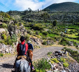 woman riding a horse in valley of volcanoes andagua 
